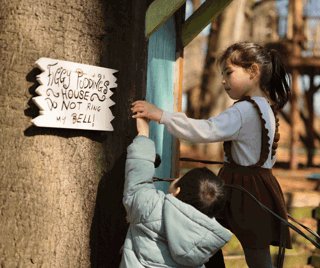 Two children pressing figgy pudding's doorbell